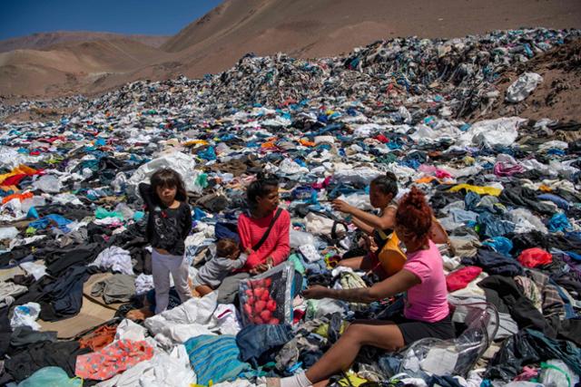 지난해 11월 칠레 한 사막에 쌓인 헌옷 쓰레기 속에서 사람들이 재활용 가능한 옷을 선별하고 있다. / 사진=연합뉴스