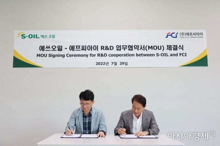 이정익 에쓰소일 전무(왼쪽)와 이태원 FCI 대표가 29일 대전 유성구 FCI 본사에서 연구개발 업무협약서에 서명하고 있다.