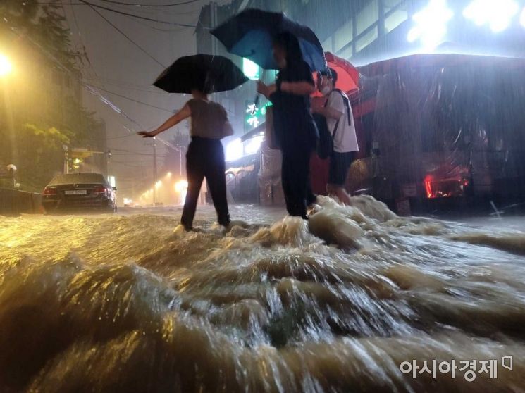 중부지방을 중심으로 강한 비가 내린 8일 밤 서울 강남구 논현역 인근 거리에서 시민들이 발걸음을 재촉하고 있다. /문호남 기자 munonam@