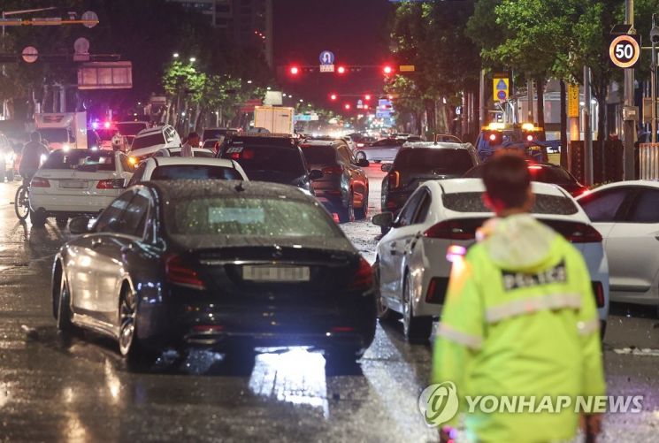 폭우가 내린 9일 오전 서울 강남구 대치역 인근 도로에 침수됐던 차들이 차량 통행을 방해하고 있다 [이미지출처=연합뉴스]