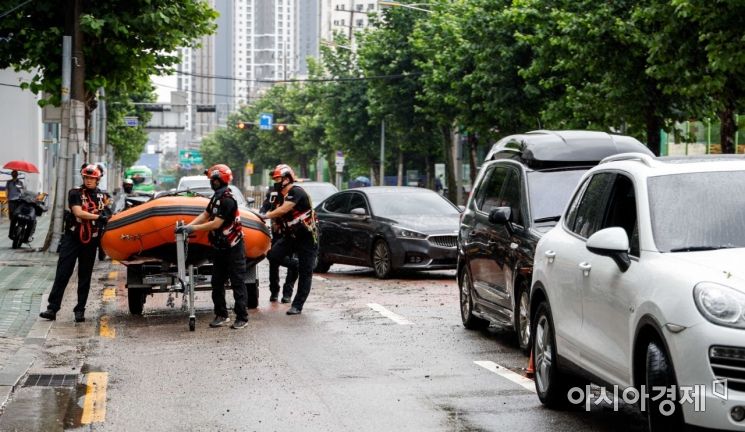 서울을 비롯한 중부지역에 기록적인 폭우가 내린 9일 서울 서초구 강남역 일대에서 소방대원들이 침수된 건물지하에 진입하기 위해 이동하고 있다./강진형 기자aymsdream@