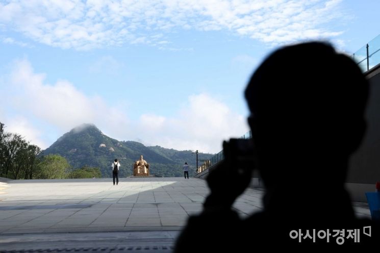 출근길 시민들이 발걸음을 멈추고 파란 하늘을 사진에 담고 있다. /문호남 기자 munonam@
