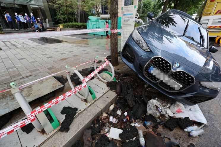 10일 오전 서울 강남역 인근 한 빌딩에서 배수 작업이 진행되고 있는 가운데 침수된 차가 방치되어 있다. [이미지출처=연합뉴스]