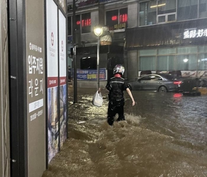 폭우 속에 배달원이 배달을 하고 있다. / 사진=온라인 커뮤니티 캡처