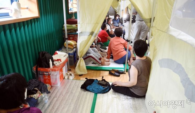 10일 구룡마을 이재민들이 박홍근 더불어민주당 원내대표 등 지도부들이 임시대피소인 구룡중학교 체육관을 찾아서 대책을 논의하자 귀기울이고 있다./국회사진기자단