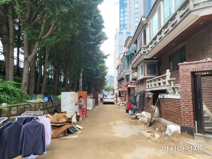 10일 오후 서울 동작구 신대방1동에서 폭우 피해를 입은 주민들이 물에 젖은 물건들을 길가에 내놓고 있다. 주민들은 물건들을 뒤적이며 쓸만한 물건은 없는지 살펴봤다./사진=오규민 기자 moh011@