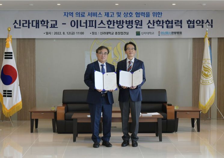 신라대 김충석 총장(왼쪽)과 이너피스한방병원 박상원 병원장이 협약식 후 기념사진을 찍고 있다.