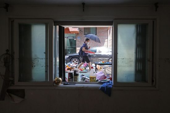 지난 8월 12일 오후 서울 관악구 신림동 일대 반지하 창문 앞에 폭우로 침수된 물품들이 널브러져 있다. [이미지출처=연합뉴스]