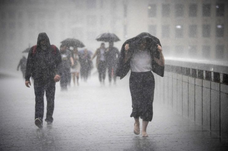 영국 런던 시내에 폭우가 내려 영국인들이 비를 맞으며 걸어가고 있다. 사진 = 연합뉴스