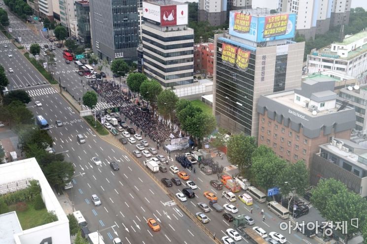민주노총 공공운수노조 화물연대가 18일 서울 강남구 하이트진로 본사 앞에서 하이트진로 집단해고 및 손배소송 철회 촉구 집회를 열고 있다. 집회로 인한 차선 축소로 주변 도로가 정체를 빚고 있다. /문호남 기자 munonam@