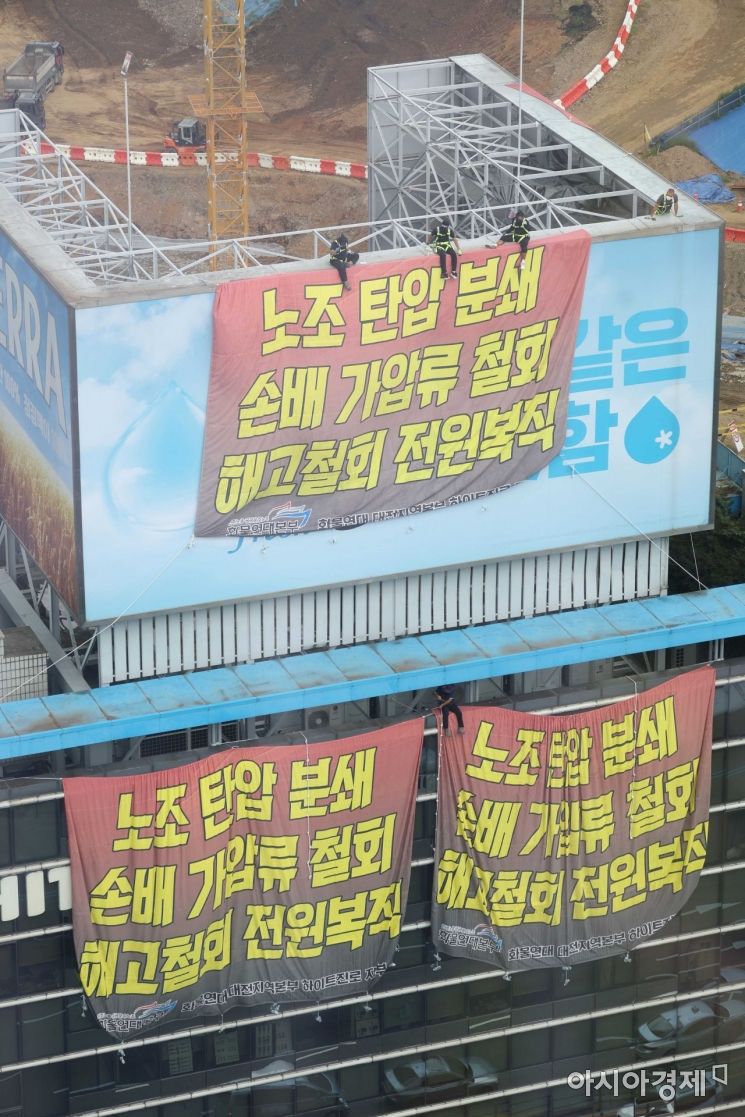 민주노총 공공운수노조 화물연대가 서울 강남구 하이트진로 본사를 점거한 채 사흘째 시위를 이어가고 있는 18일 건물 외벽에 요구사항이 적힌 현수막이 걸려 있다. /문호남 기자 munonam@