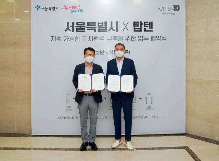 이인근 서울시 환경기획관(왼쪽)과 염태순 신성통상 회장(오른쪽)이 18일 신성통상 본사에서 업무협약 맺고 기념촬영을 하고 있다.