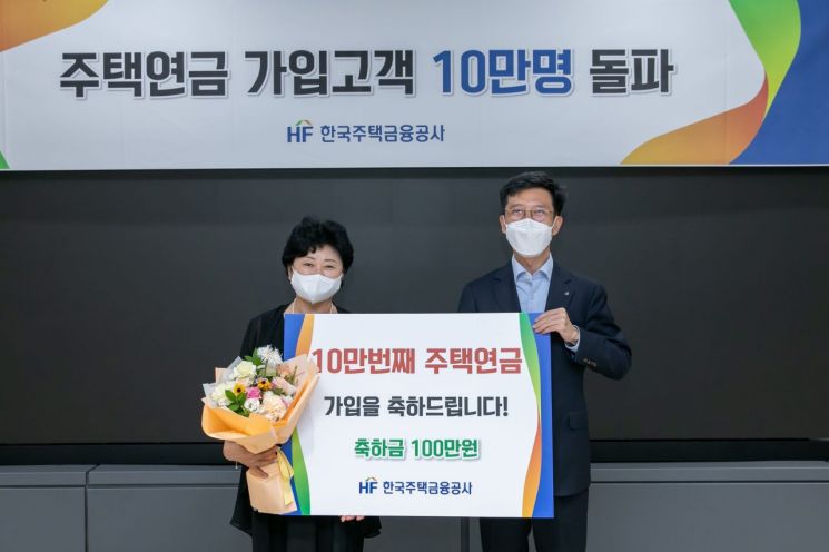 최준우 주택금융공사 사장(오른쪽)이 18일 서울시 세종대로 WISE타워에서 주택연금 10만번째 가입자 김희숙 씨에게 축하금을 전하고 있다.