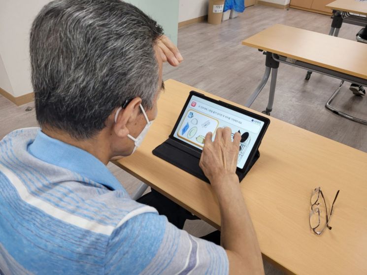 지난 17일 서울 성북구치매안심센터에서 최종찬 할아버지가 테블릿에 설치된 앱을 이용해 일상생활에서 필요한 '자가돌봄기술' 훈련을 받고 있다.
