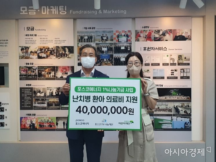 이전혁 포스코에너지 기획지원본부장(왼쪽)이 23일 초록우산어린이재단에서 신정원 초록우산어린이재단 본부장에게 난치병 환아 치료비를 전달하고 기념촬영을 하고 있다.