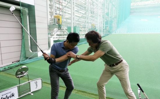 A golfer is receiving a lesson at an outdoor golf practice range. [Image source=Yonhap News]