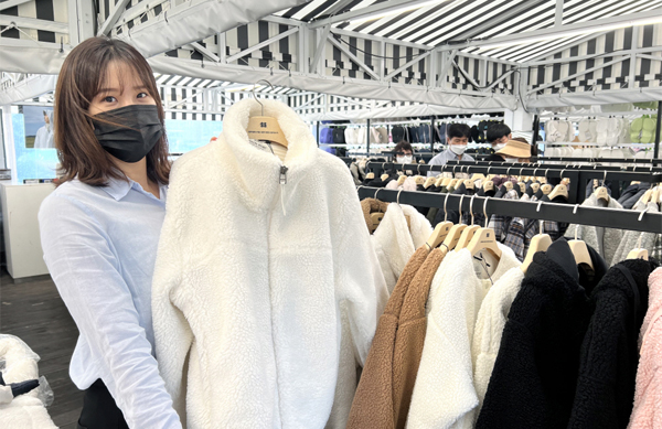 현대프리미엄아울렛 김포점에서 직원이 역시즌 행사 상품을 소개하고 있다.