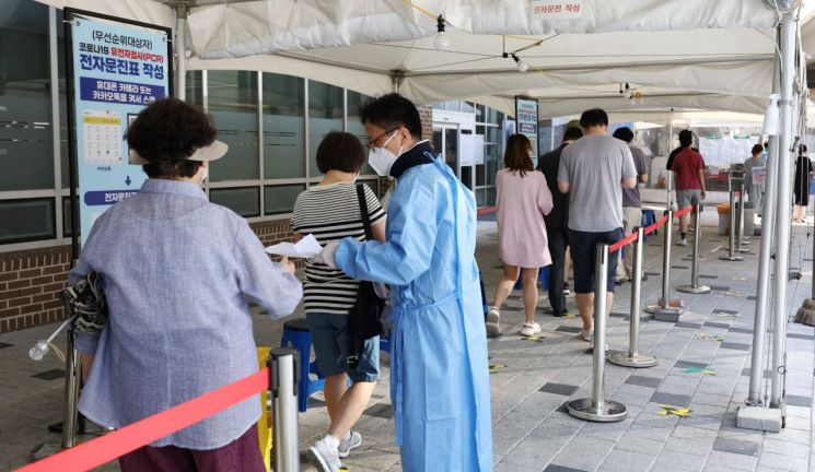 지난달 26일 서울 마포구보건소 코로나19 선별진료소에서 시민들이 검사를 받기 위해 줄을 서고 있다. [이미지출처=연합뉴스]