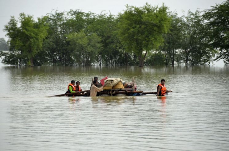 지난달 28일(현지시간) 파키스탄 남서부 발루치스탄주 자파라바드에서 이재민들이 가재도구를 뗏목에 싣고 홍수 지역을 빠져나가고 있다. [이미지출처=연합뉴스]