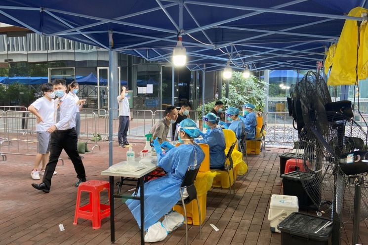 중국 광둥성 선전시에서 보호복을 입은 의료진이 코로나19 검사를 하고 있다.＜이미지출처:연합뉴스＞