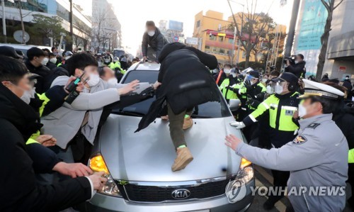 지난 2020년 12월12일 형기를 마치고 출소한 아동 성범죄자 조두순이 탑승한 관용차량이 경기도 안산시 법무부안산준법지원센터에서 나오던 중 일부 시민과 유튜버 등에 가로막혀 있다. [이미지출처=연합뉴스]