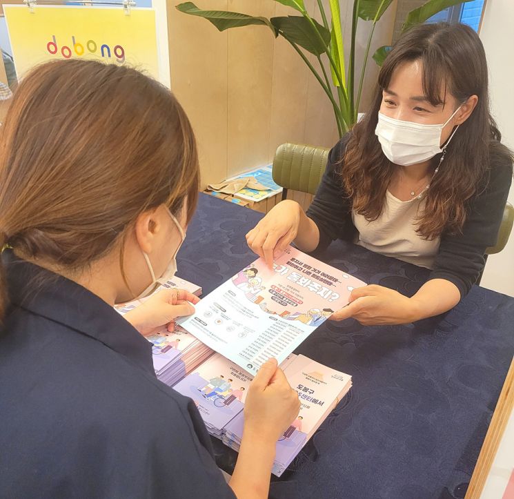도봉구 도봉여성센터 양성평등주간 행사에서 돌봄SOS센터 관계자가 구민에게 긴급돌봄 등에 대해 설명하고 있다.