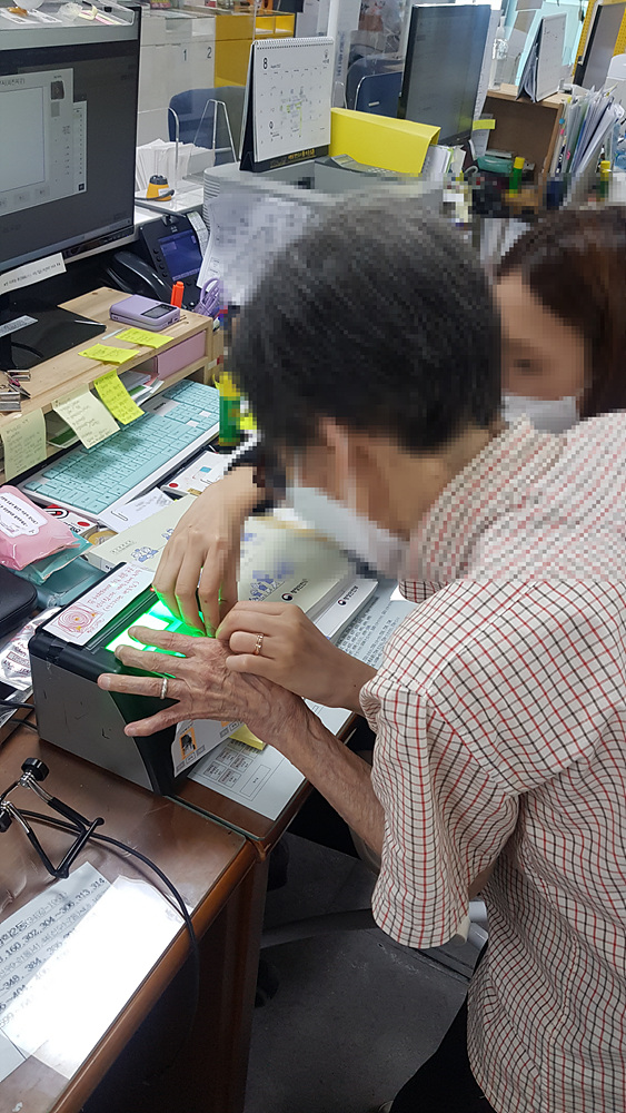 도봉구 방학2동 주민센터 주민등록 담당 직원이 A씨(왼쪽) 지문을 등록하고 있다.