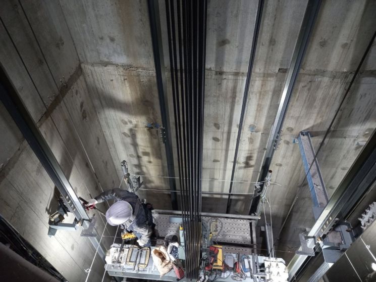 승강기 업체 직원이 고층건물의 승강로에서 설치작업을 하고 있다. [사진제공=S리프트].