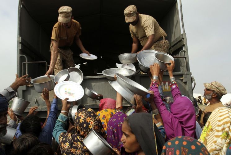 파키스탄 군인들이 지난달 27일(현지시간) 펀자브주 라잔푸르의 홍수 피해 지역에서 이재민들에게 음식을 나눠주고 있다. [이미지출처=AP연합뉴스]