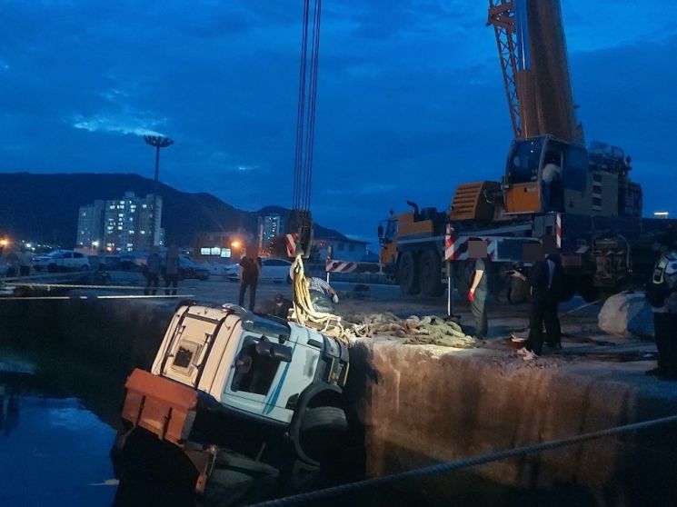 경남 사천시 삼천포신항에서 바다로 추락한 화물차량을 크레인이 끌어올리고 있다. [이미지출처=사천해양경찰서]