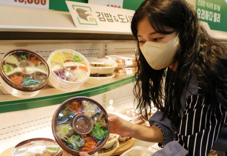 서울 롯데마트 서울역점에서 모델이 비빔밥 도시락을 소개하고 있다.