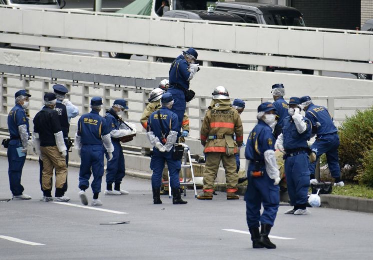21일 도쿄의 총리 관저 인근에서 국장에 반대하는 시민이 분신을 시도한 것으로 추정되는 현장을 경찰관과 소방관들이 조사하고 있다. [이미지출처=연합뉴스]
