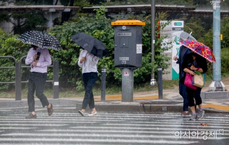 강한 바람을 동반한 소나기가 내리고 있는 23일 서울 용산구에서 시민들이 우산을 붙잡고 이동하고 있다./강진형 기자aymsdream@