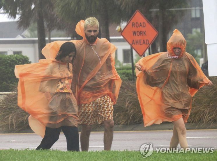 허리케인 이언이 미국 플로리다주에 접근하면서 많은 비를 쏟아붇자 주민들이 우비를 입고 이동하고 있다. 사진=AP연합뉴스