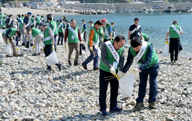 HJ중공업 임직원들이 부산 영도 중리해변에서 태풍 쓰레기들을 줍고 있다.