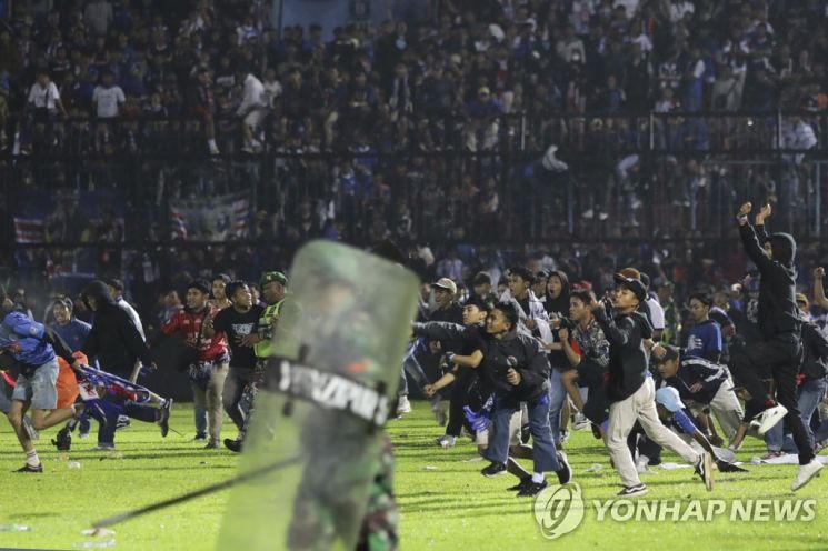 경찰은 그라운드로 난입한 팬들을 저지하기 위해 최루탄을 쏘며 진압에 나섰다. 발사 소리에 놀란 관중들이 한꺼번에 빠져나가려다 대규모 압사 사고가 발생했다. 사진=AP연합뉴스