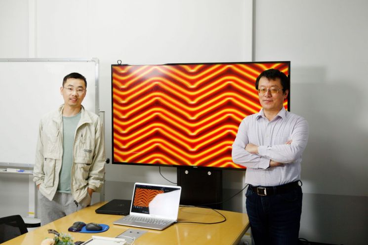 이번 연구를 주도한 패이 리(Pai Li) 박사(왼쪽)와 펑 딩(Feng Ding) 특훈교수가 금(111)의 나노 표면을 배경으로 사진을 찍고 있다.