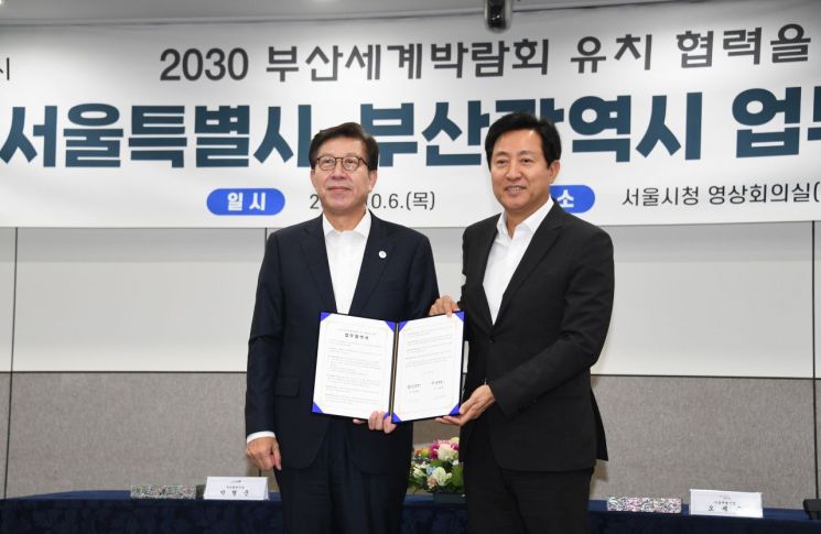 오세훈 서울시장(왼쪽)과 박형준 부산시장(오른쪽)이  6일 서울시청에서 만나 '2030 부산세계박람회' 유치 협력을 위한 업무협약을 체결하고 기념사진을 촬영하고 있다.