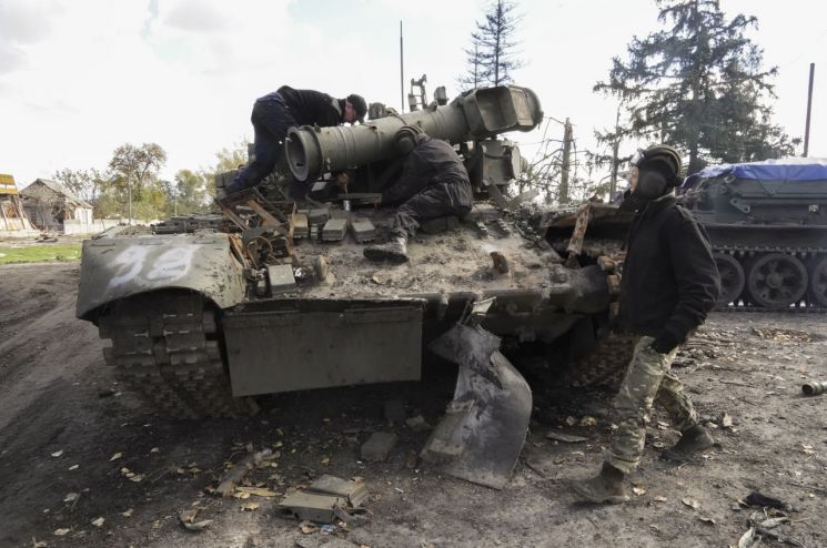 지난 4일(현지시간) 우크라이나 군인들이 하르키우 지역에서 노획한 러시아 탱크를 견인할 준비를 하고 있다. [이미지출처=EPA연합뉴스]