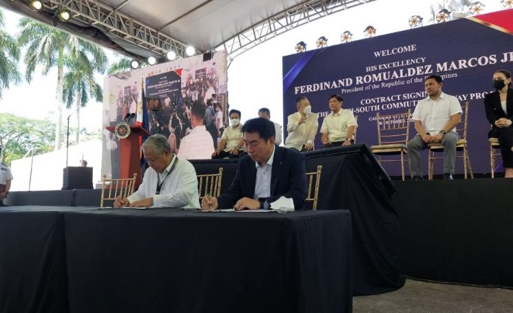 제이미 바티스타 필리핀 교통부장관(왼쪽)과 롯데건설 김종수 토목사업본부장(오른쪽)이 계약서에 서명하고 있는 모습.  ＜사진제공=롯데건설＞