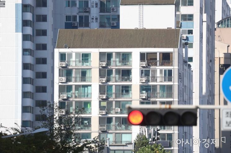 한국은행이 기준금리를 0.5% 포인트 올리면서 부동산 거래시장의 빙하기가 장기화될 것으로 보인다. 13일 서울 시내 한 아파트 인근 신호등에 빨간불이 켜져 있다.
