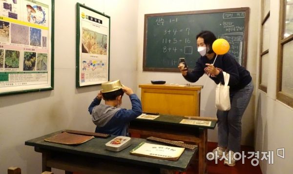 광주지역 대표 축제로 자리매김한 '충장축제'가 막이 오른 13일 한 시민이 옛 추억을 떠올리며 함께 온 아들의 사진을 찍어주고 있다.