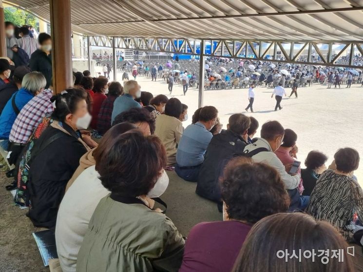 내리쬐는 햇빛을 피해 그늘이 있는 돌계단에 앉아 있는 둔촌주공 조합원들 모습. / 사진=황서율 기자chestnut@
