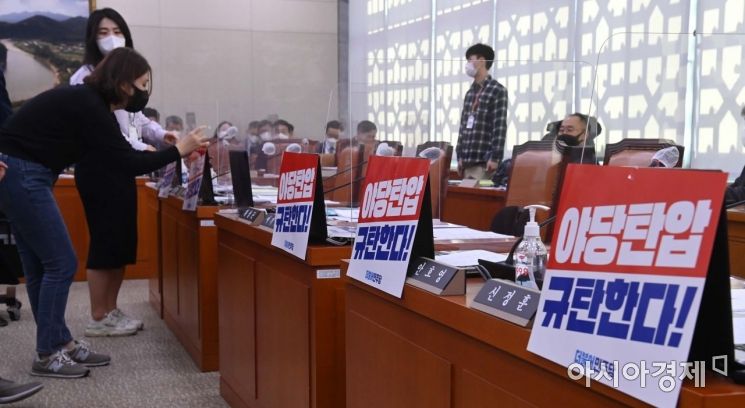더불어민주당 관계자들이 20일 국회에서 열린 농림축산식품부 등에 대한 국정감사에서 감사 시작 전 야당탄압을 규탄하는 구호가 적힌 피켓을 붙이고 있다./윤동주 기자 doso7@