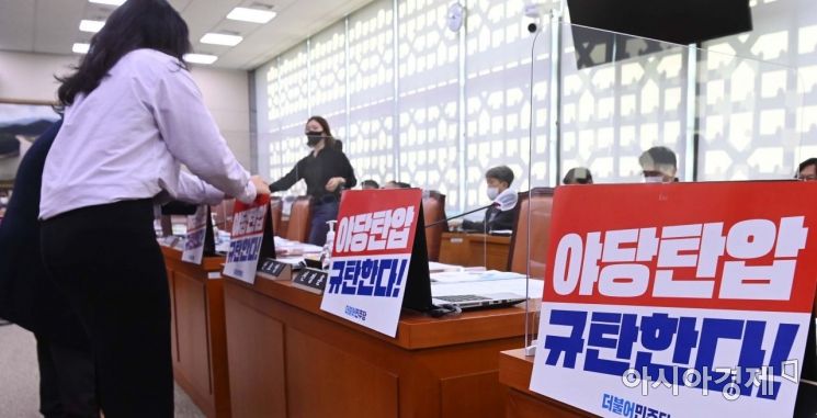 더불어민주당 관계자들이 20일 국회에서 열린 농림축산식품부 등에 대한 국정감사에서 감사 시작 전 야당탄압을 규탄하는 구호가 적힌 피켓을 붙이고 있다./윤동주 기자 doso7@