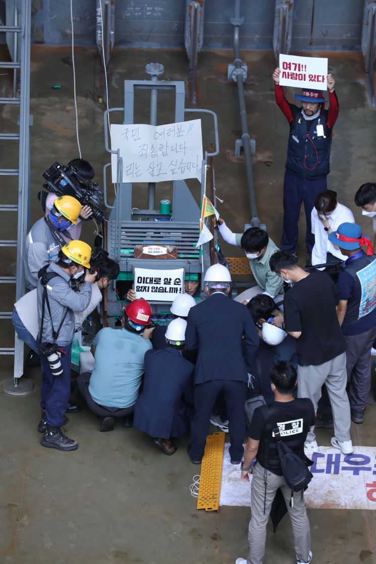 이정식 고용노동부 장관이 지난 7월 19일 오후 경남 거제시 아주동 대우조선해양 옥포조선소 파업 현장을 방문해 조선소 독 화물창 바닥에 가로, 세로, 높이 각 1ｍ 철 구조물 안에서 농성 중인 유최안 금속노조 거제통영고성 조선하청지회 부지회장과 면담하고 있다. [이미지출처=연합뉴스]