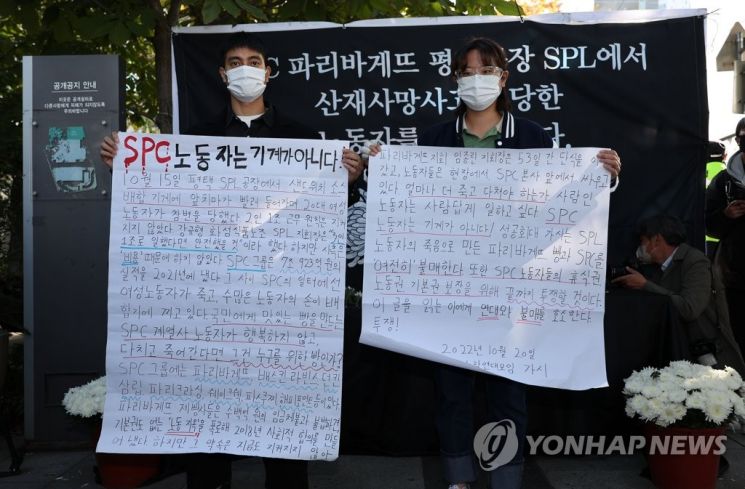 20일 오후 서울 양재동 SPC 본사 앞에서 열린 평택 SPC 계열사 SPL의 제빵공장 사망 사고 희생자 서울 추모행사에서 성공회대 노학연대모임 가시 관계자가 대자보를 펼치고 있다. [이미지출처=연합뉴스]