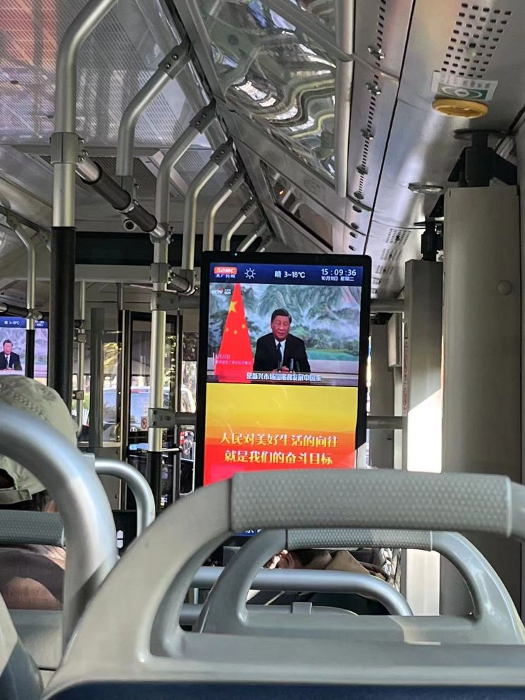 베이징 시내를 다니는 한 버스 내에 설치된 스크린 화면. 화면에는 3연임을 앞둔 시진핑 중국 국가주석이 연설을 하며 그간의 경제성장을 홍보하고 있다.