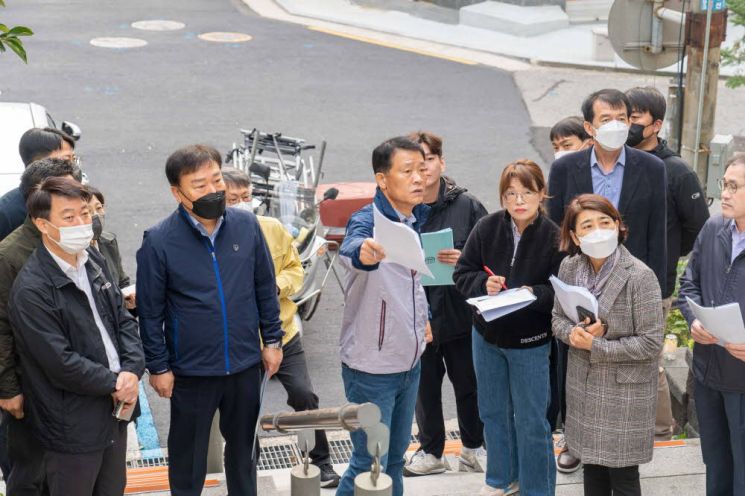 이승로 성북구청장(가운데)이 2022 ‘1일 현장구청장실’ 운영을 2주가량 앞둔 지난 14일 주민제안사항에 대해 구청 관계 부서 직원들과 함께 성북동 현장을 살펴보며 해결방안을 논의하고 있다.