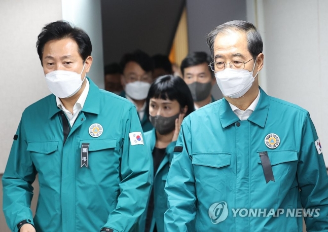 지난달 30일 한덕수 국무총리(오른쪽)와 오세훈 서울시장이 서울시청에서 용산구 이태원 참사와 관련한 상황 점검을 위해 상황실로 들어서고 있다. 오 시장은 '근조' 표시가 들어간 리본을, 한 총리는 글씨 없는 리본을 착용했다. [이미지출처=연합뉴스]